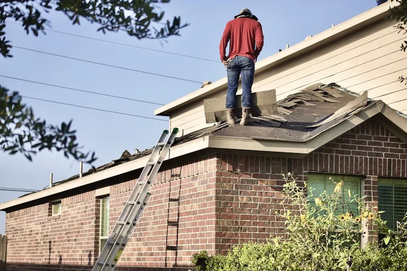 Professional roofer working on a residential roof in Point Lakeview